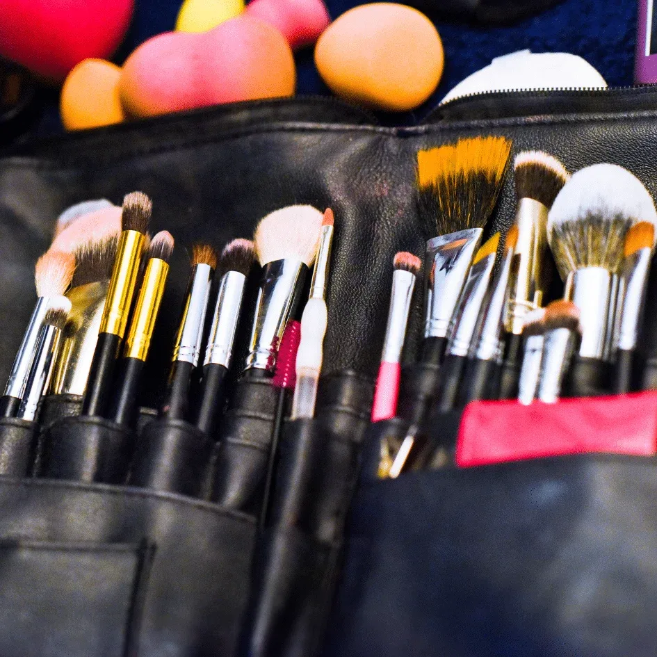 Conjunto de pinceles de maquillaje almacenados en un estuche de cuero.