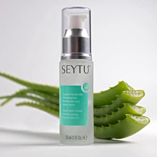 Botella de Suero Facial de Hidratación Profunda con Aloe Vera de SeyTú, con una hoja de aloe vera en el fondo.